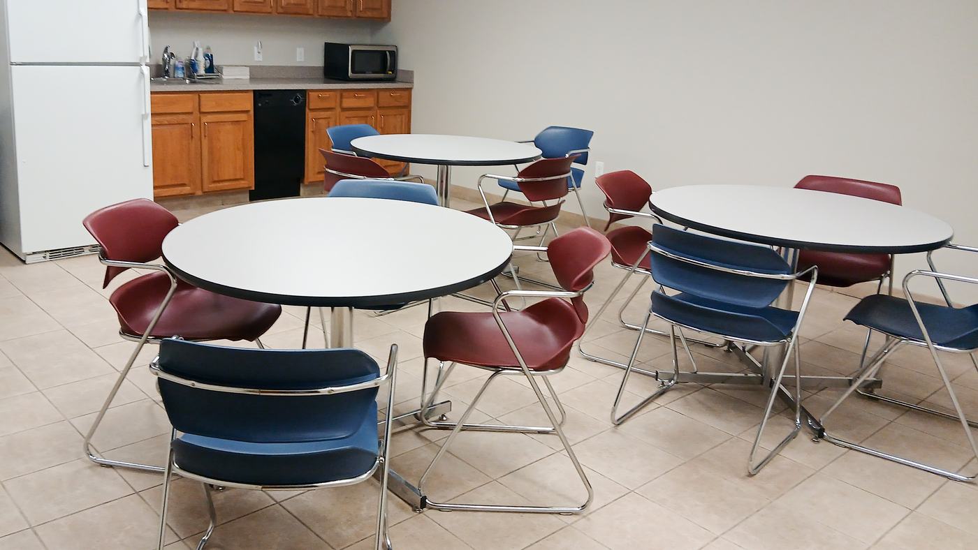 Kitchen and break room with round tables and chairs